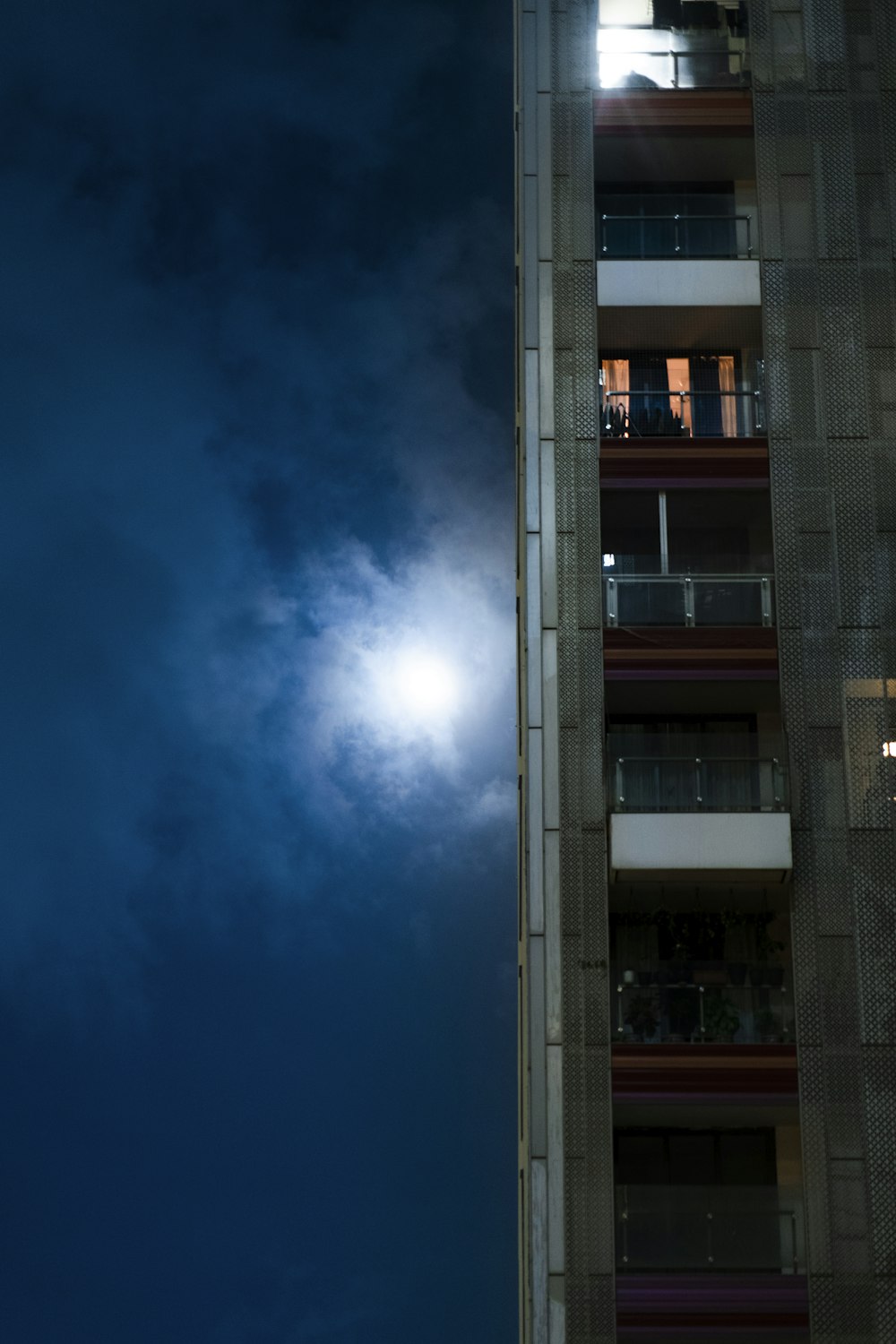 a tall building with a full moon in the background