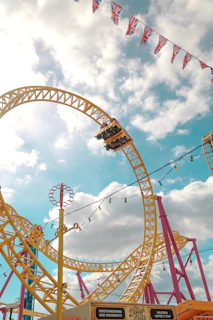A cheerful UK family enjoying a sunny day at an Orlando theme park, with colorful rides and palm trees in the background.