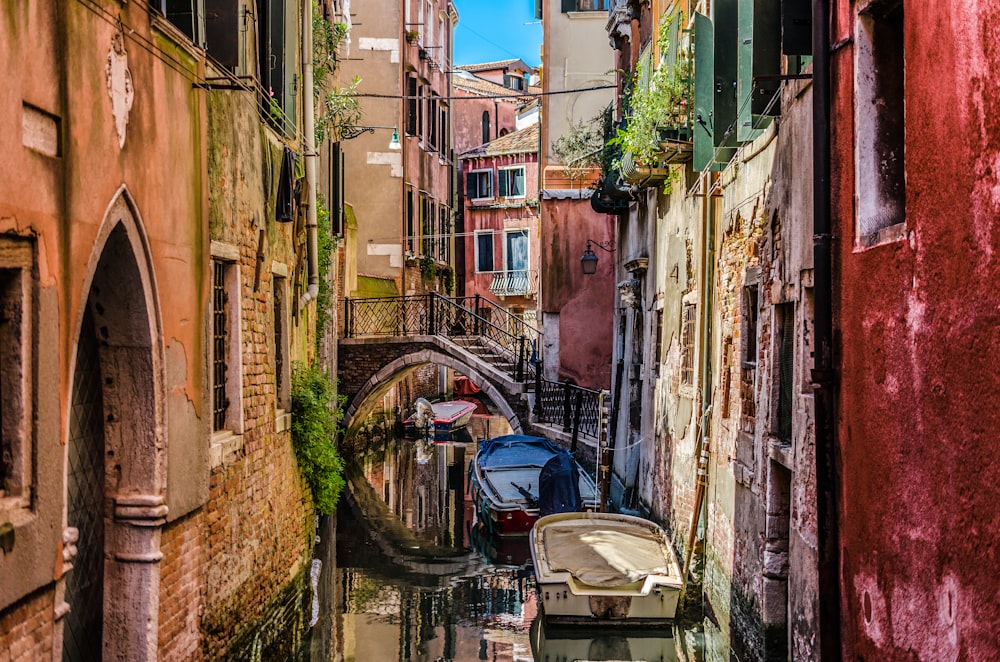 a narrow canal with several boats in it