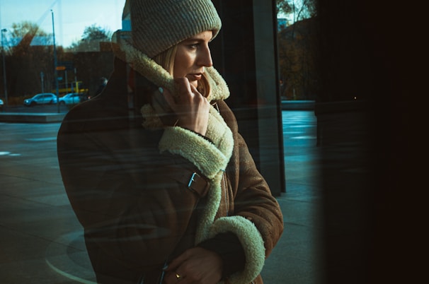 a man talking on a cell phone while wearing a hat