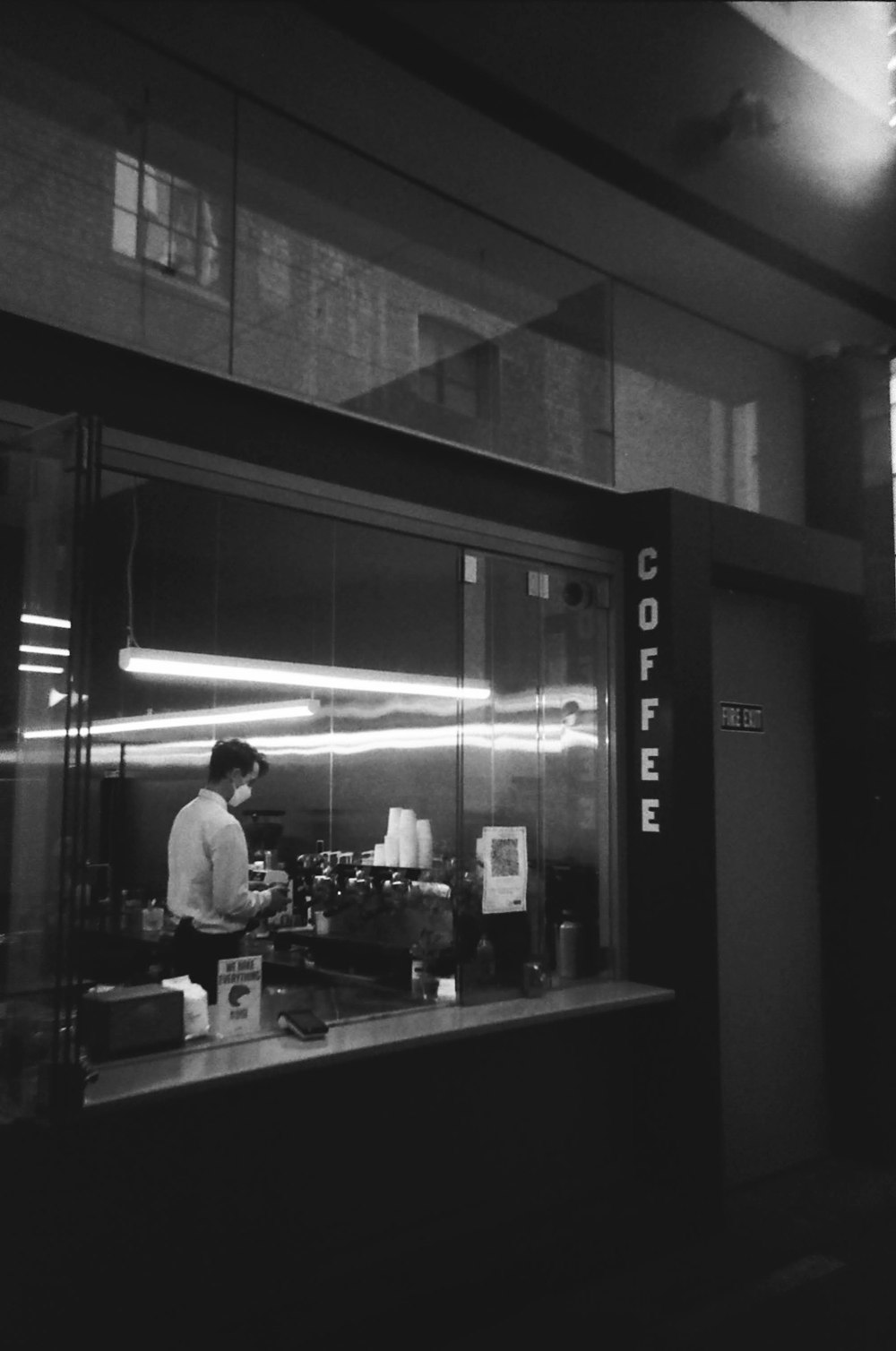 a black and white photo of a man working in a coffee shop