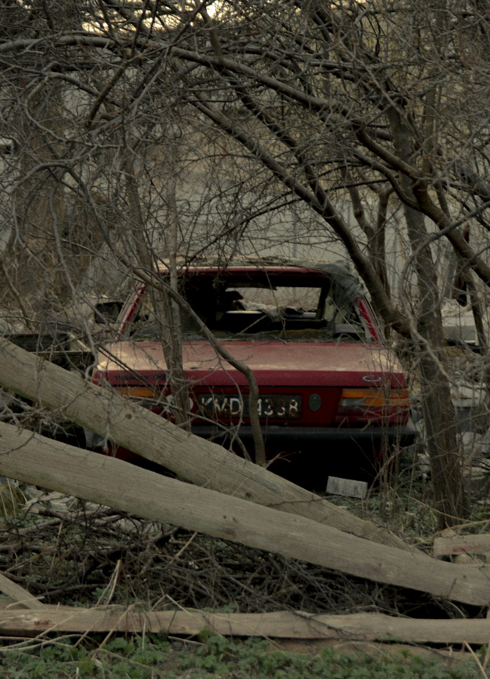 a red pickup truck parked in a wooded area