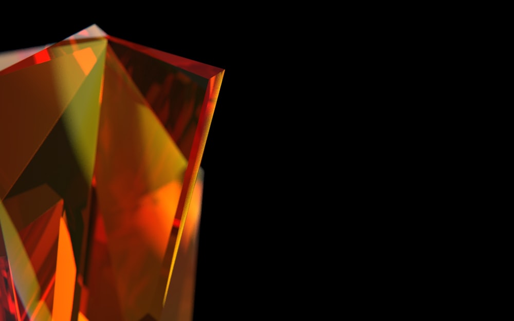 a close up of an orange diamond on a black background