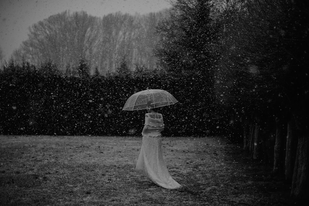 a woman in a white dress holding an umbrella