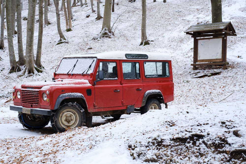a red jeep is parked in the snow