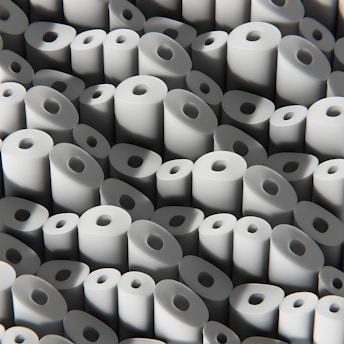 Close-up of soft, white tissue paper rolls stacked neatly in a bright factory setting.