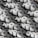 A large number of white paper rolls are tightly packed together, creating a uniform and repetitive pattern. Each roll has a circular hole in the center, and they are arranged in various orientations, contributing to the overall texture and visual interest.