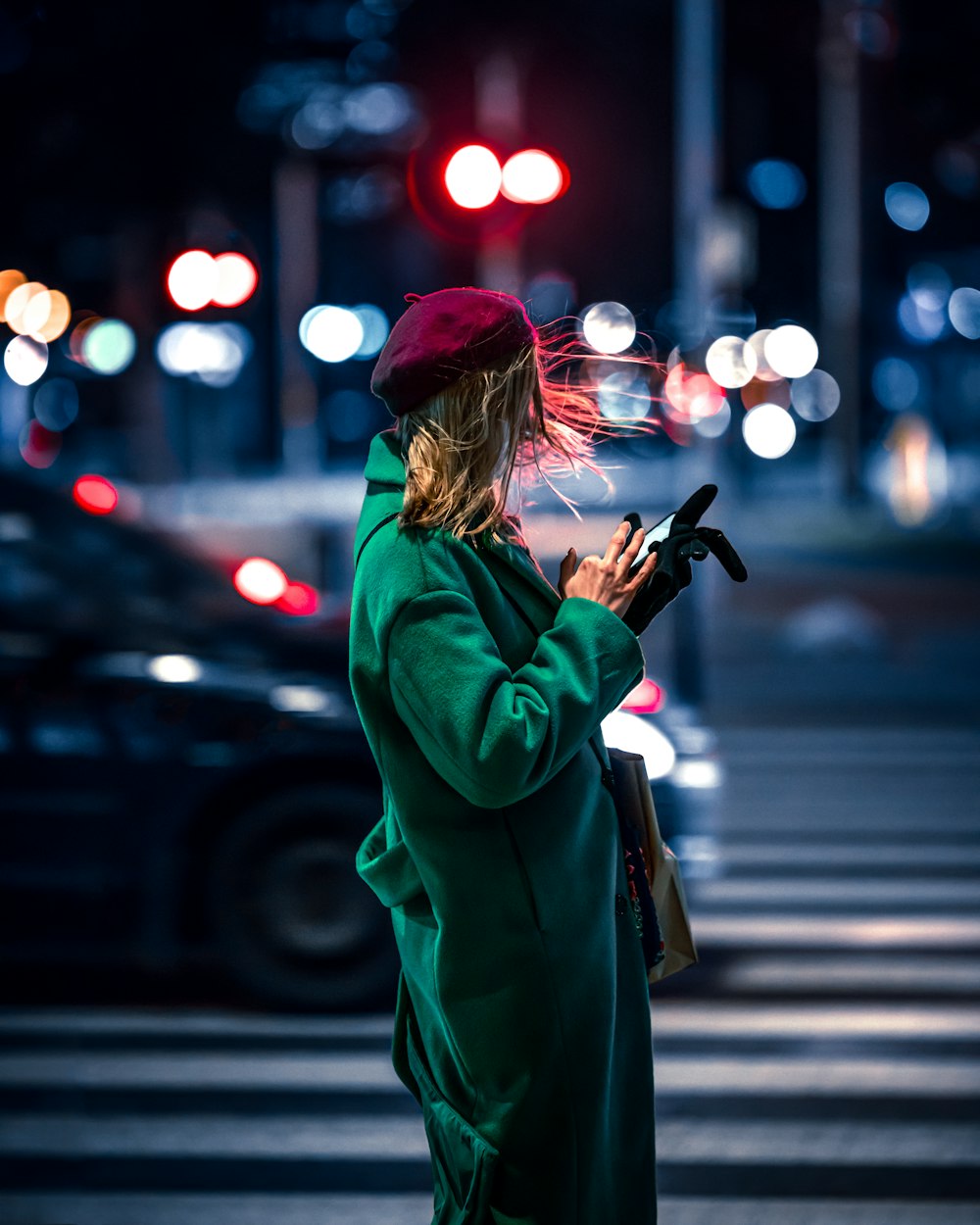 a woman in a green coat is using her cell phone