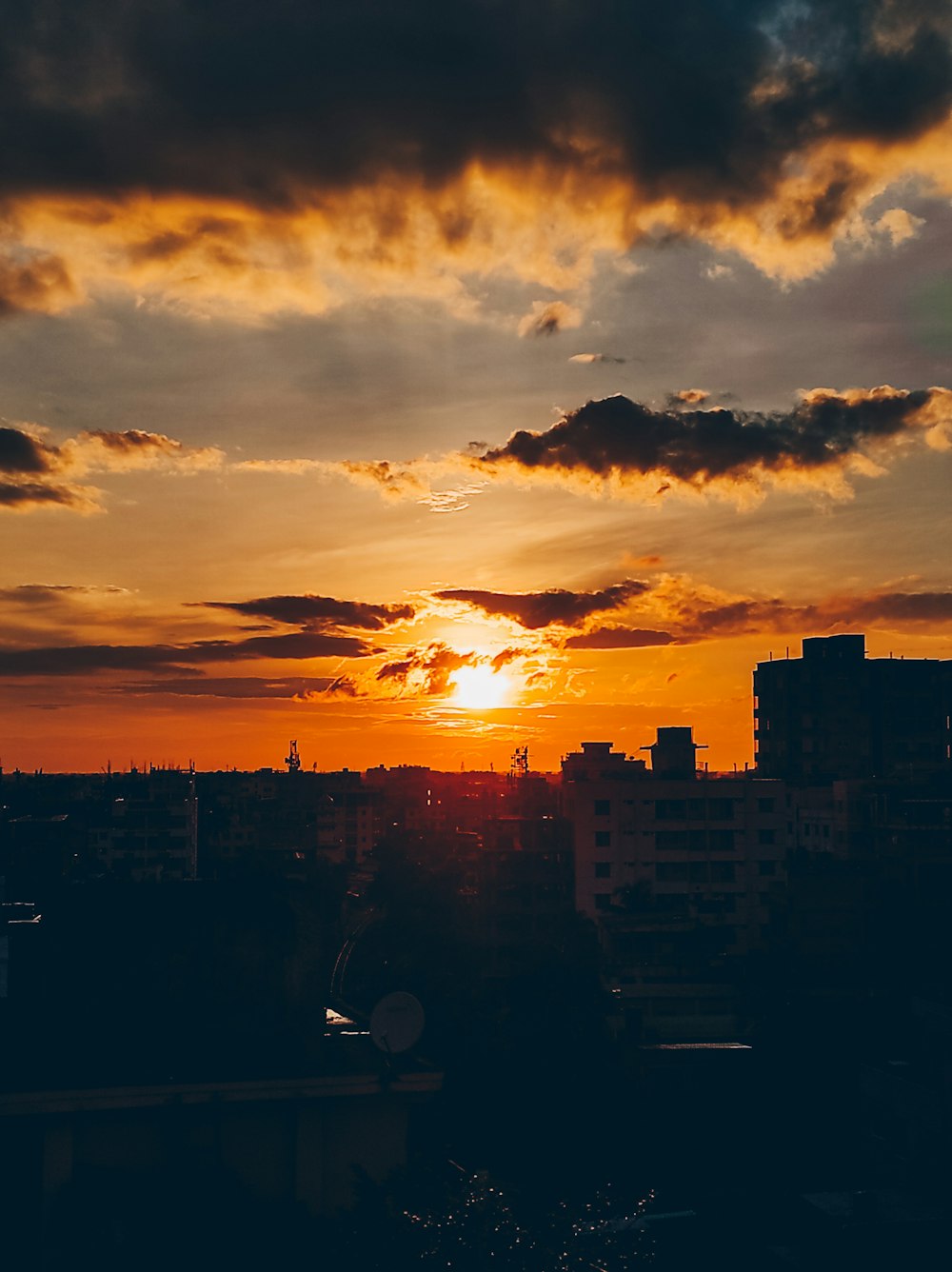 the sun is setting over a city with tall buildings