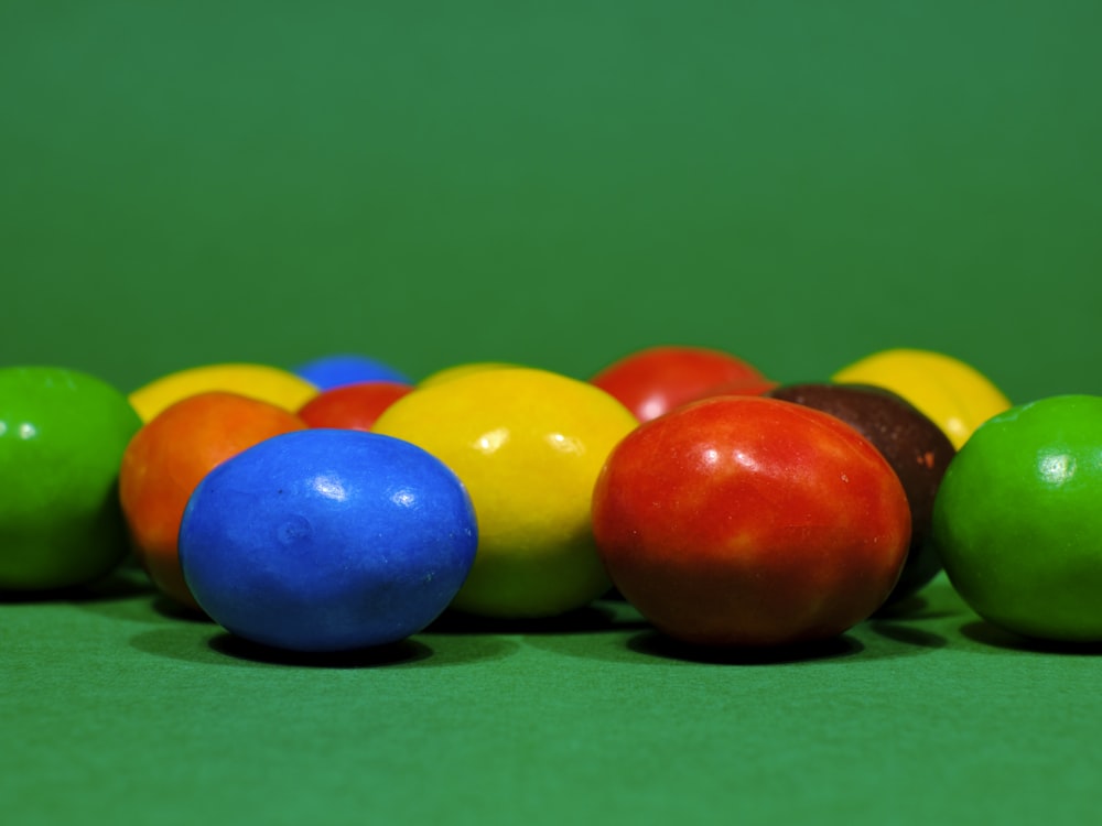 a row of colorful balls sitting on top of a green table