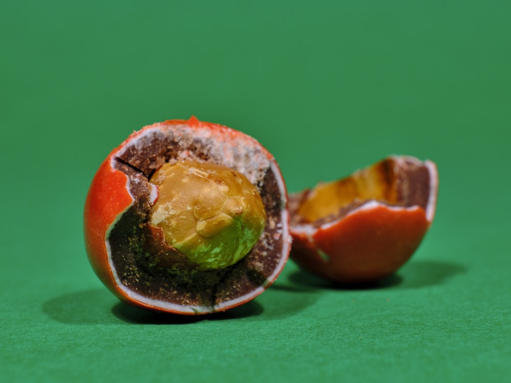 a half eaten orange sitting on top of a green table