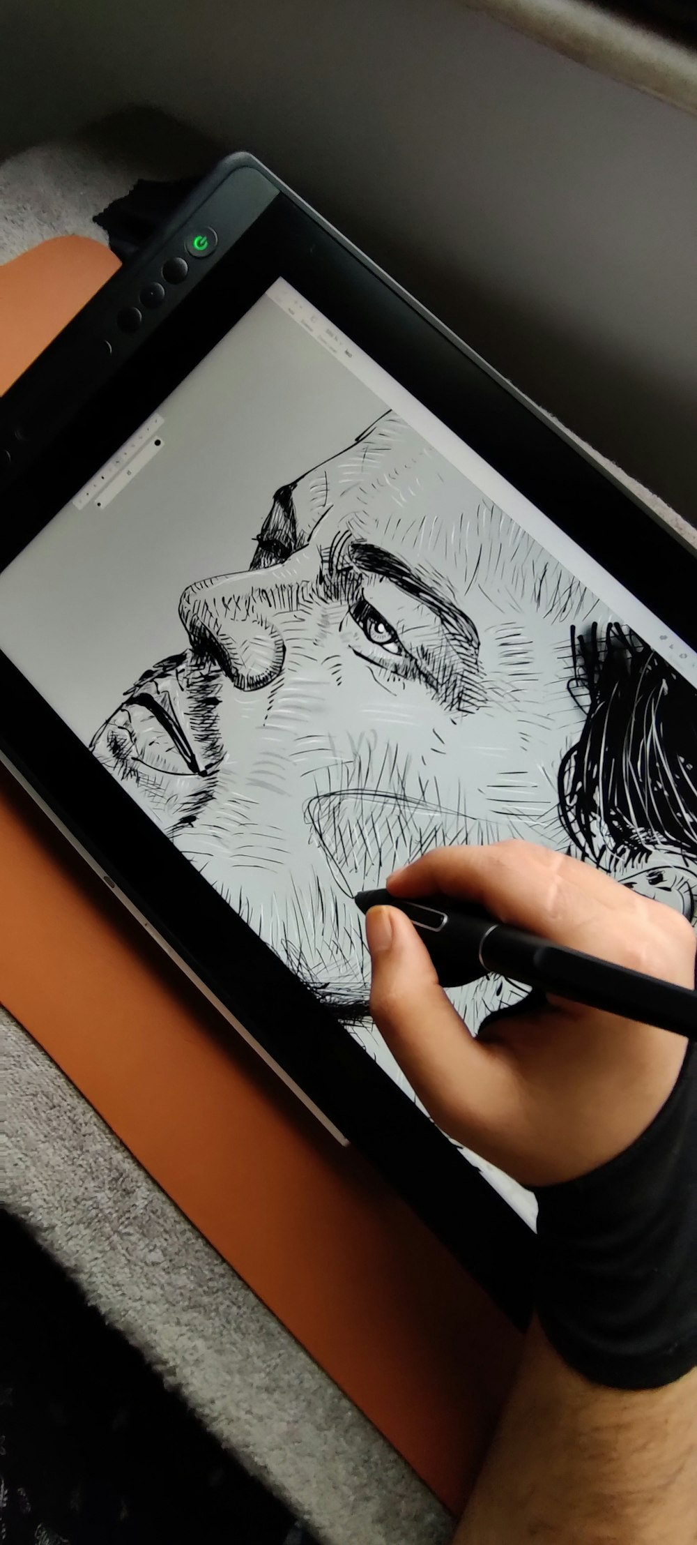 a person is drawing on a tablet with a pen