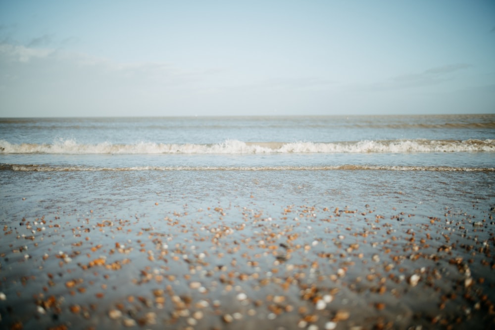 a beach with a wave coming in to shore