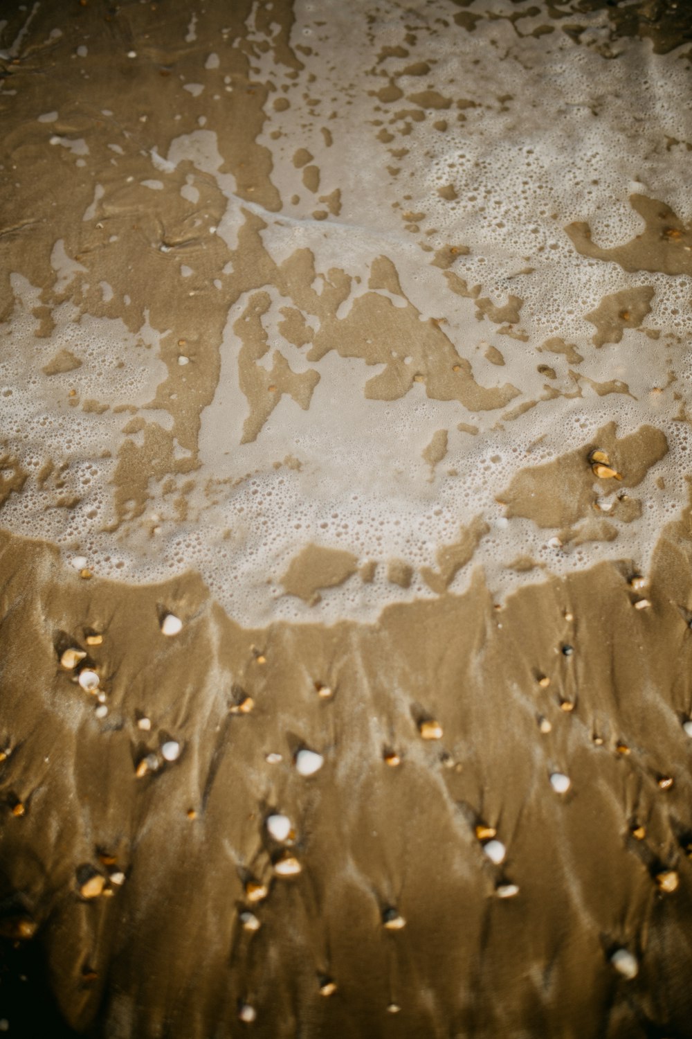 a close up of sand and water on a beach