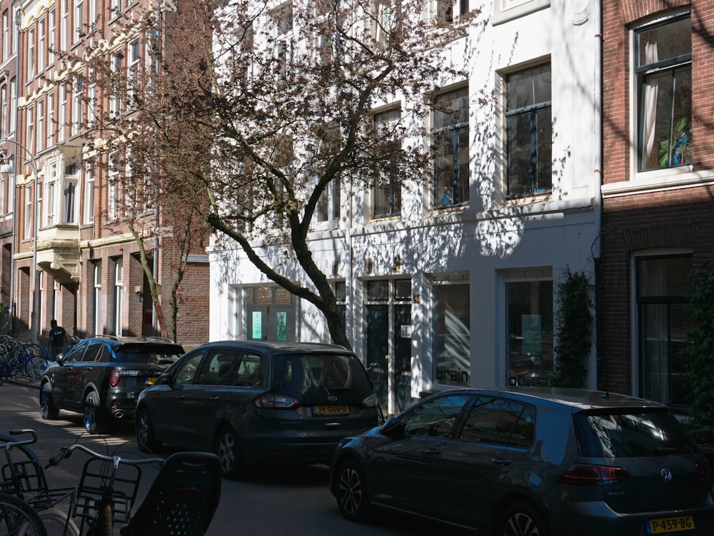 cars parked on the side of a street next to tall buildings