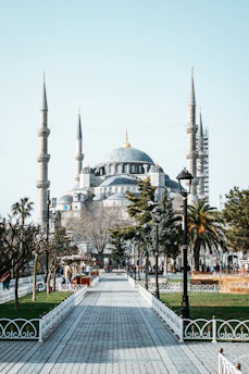 a walkway leading to a large building with many spires