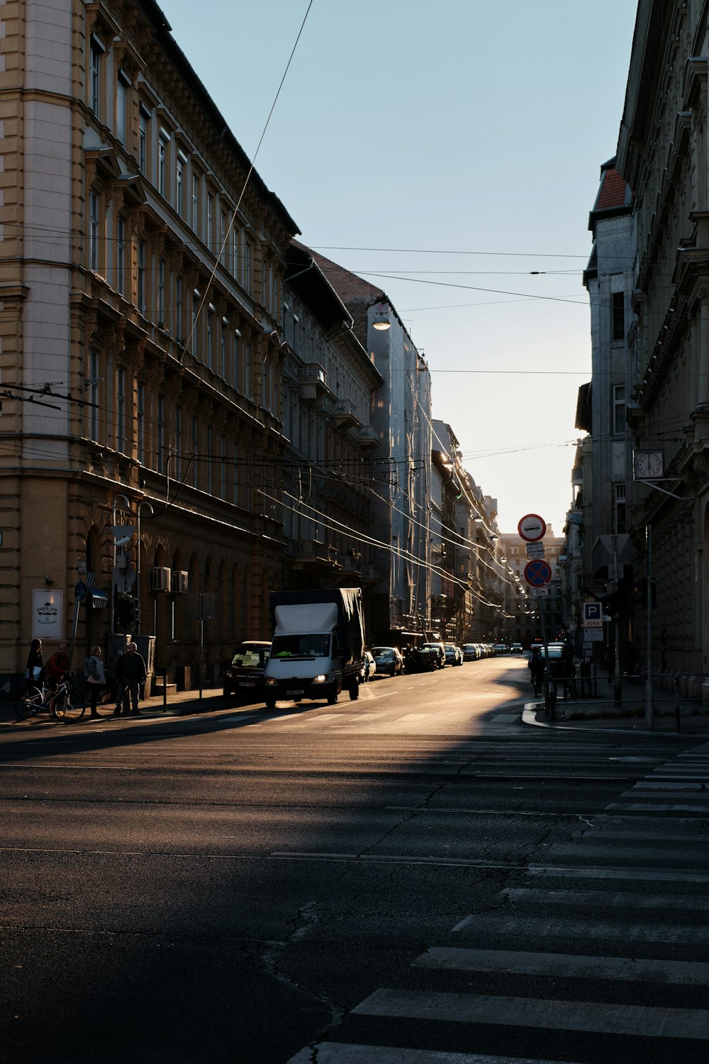 a city street with cars and people walking on the sidewalk