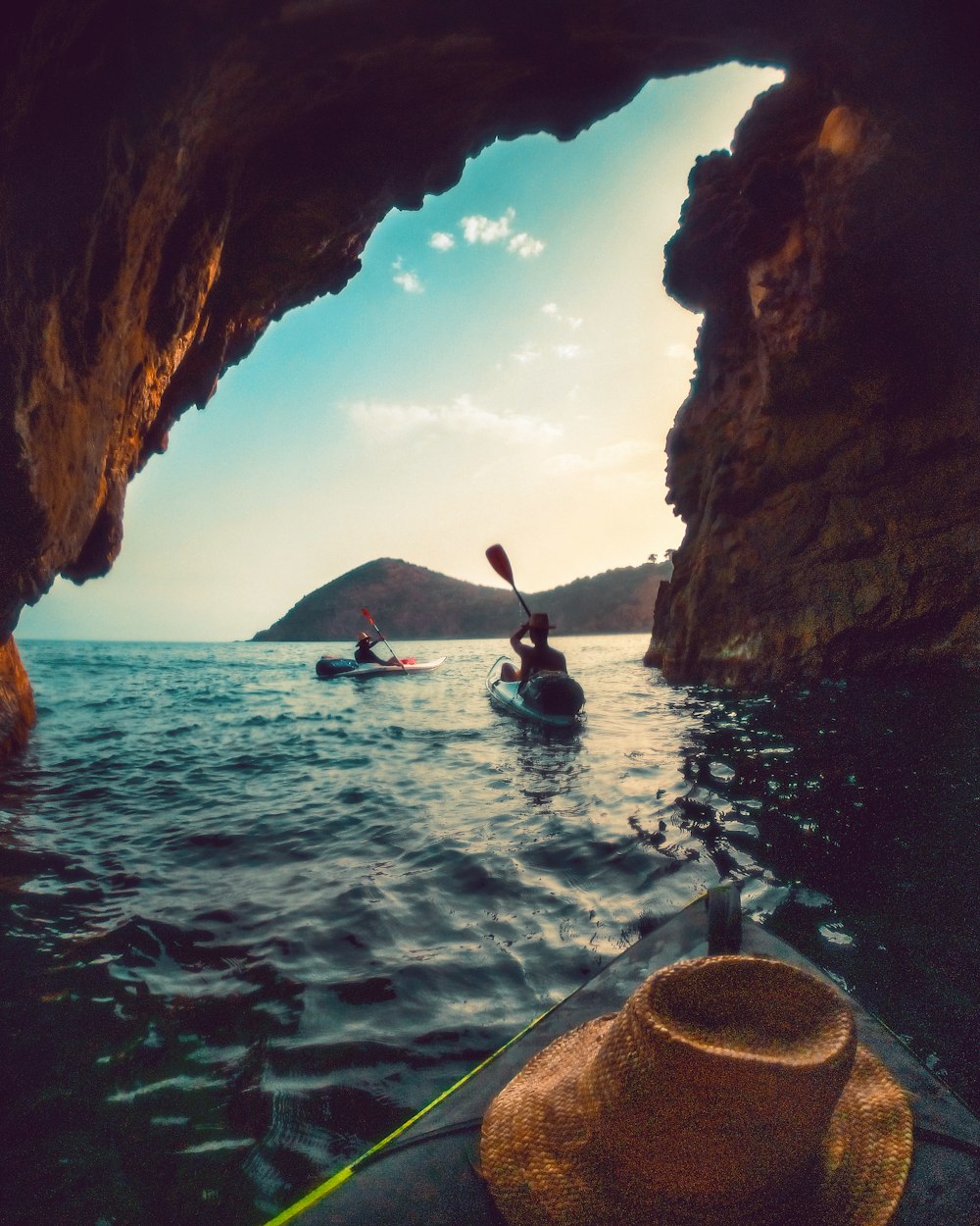 two people in kayaks paddling through a cave