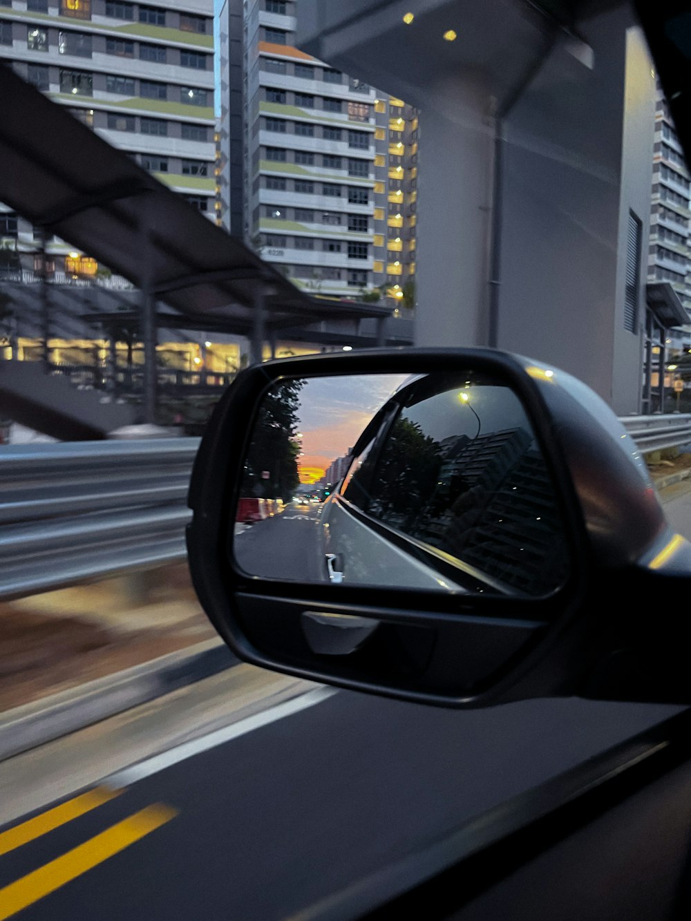 a car's side view mirror on the side of the road