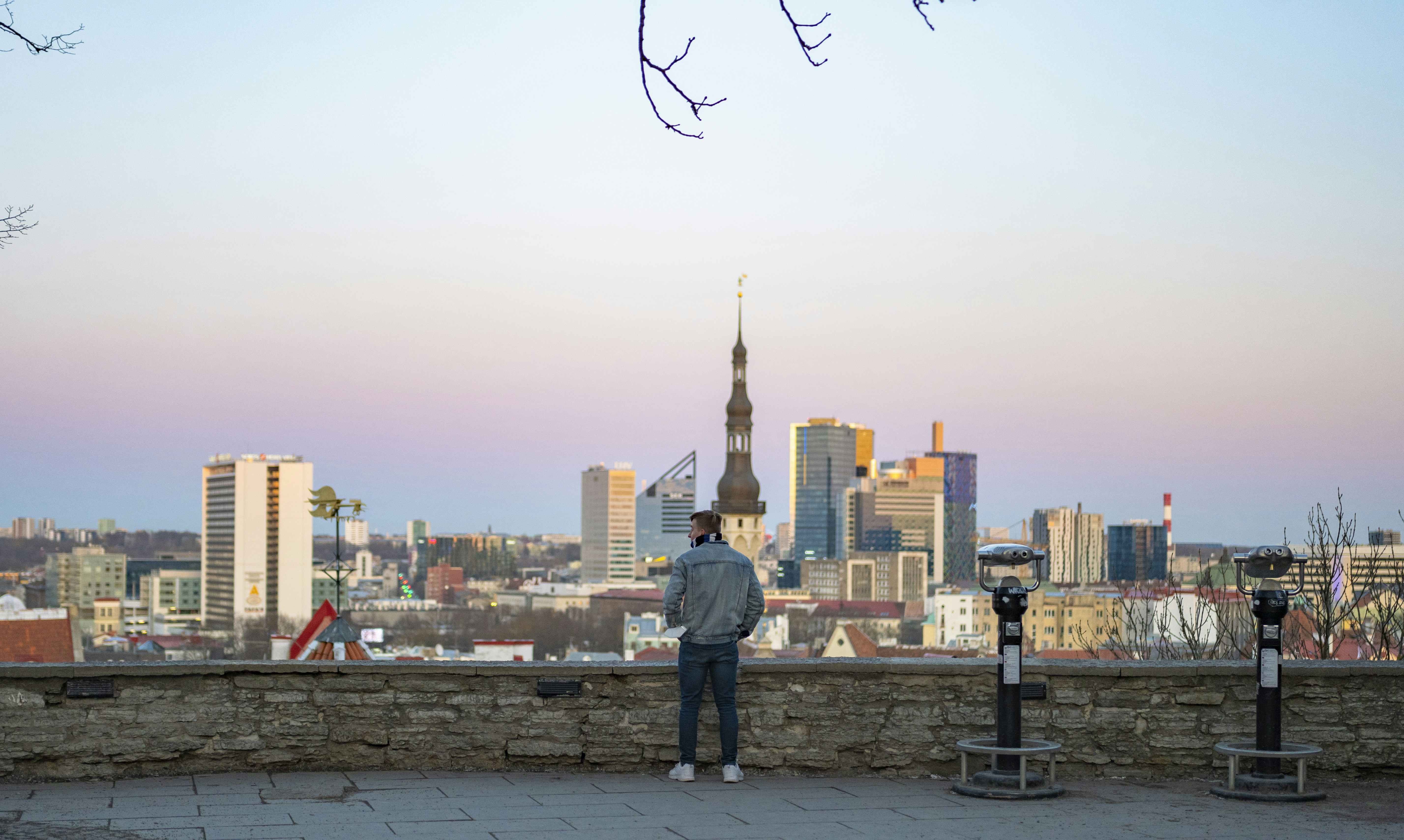 街を背景に石垣の上に立つ男