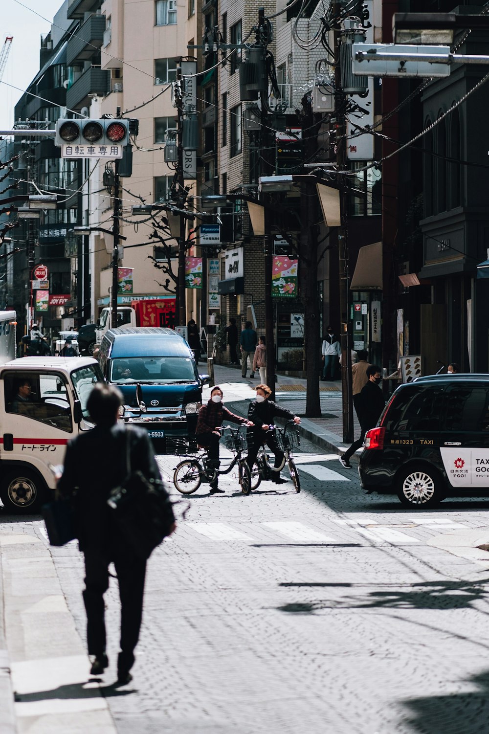 a man walking down a street next to parked cars