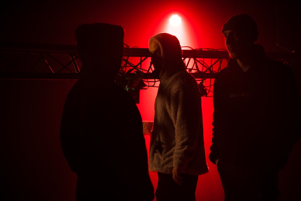 a group of people standing in front of a red light