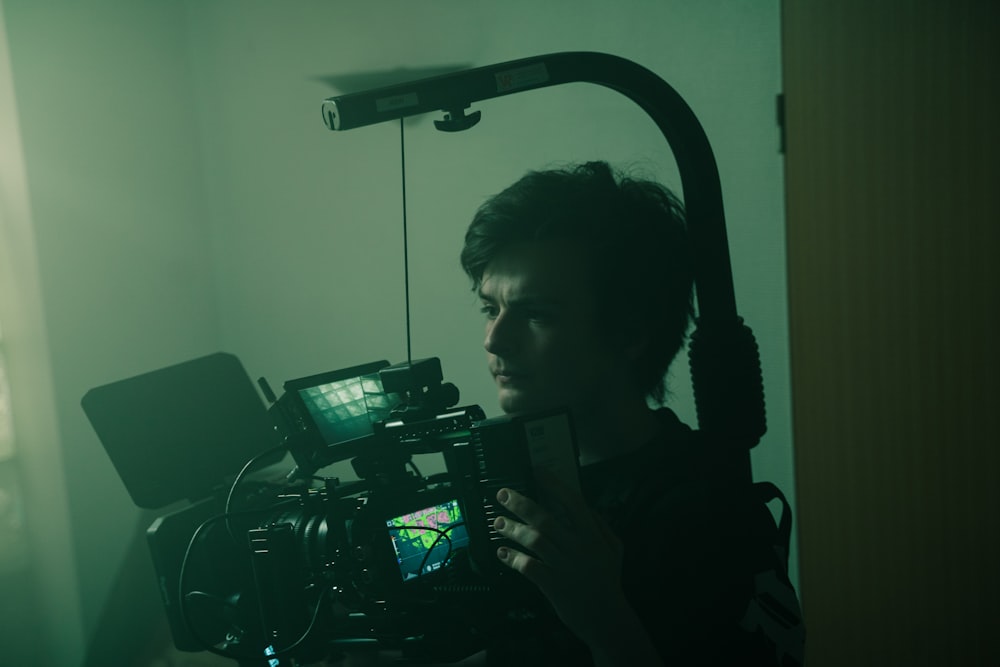 a man holding a camera in a dark room