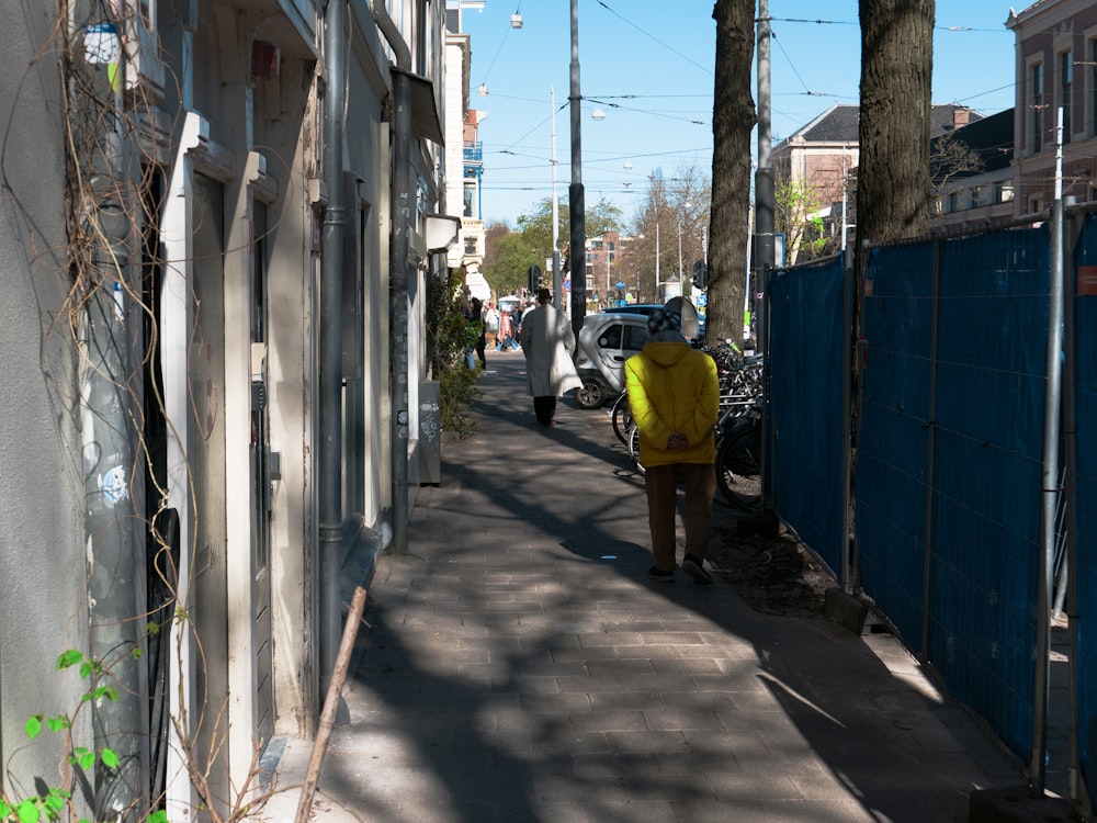 uma pessoa em uma jaqueta amarela andando por uma rua