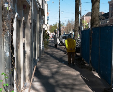 a person in a yellow jacket walking down a street