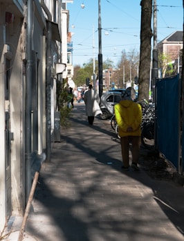 a person in a yellow jacket walking down a street