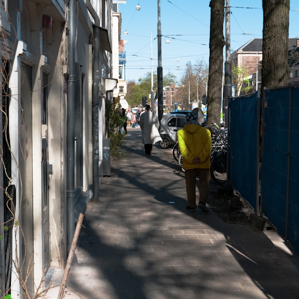 a person in a yellow jacket walking down a street
