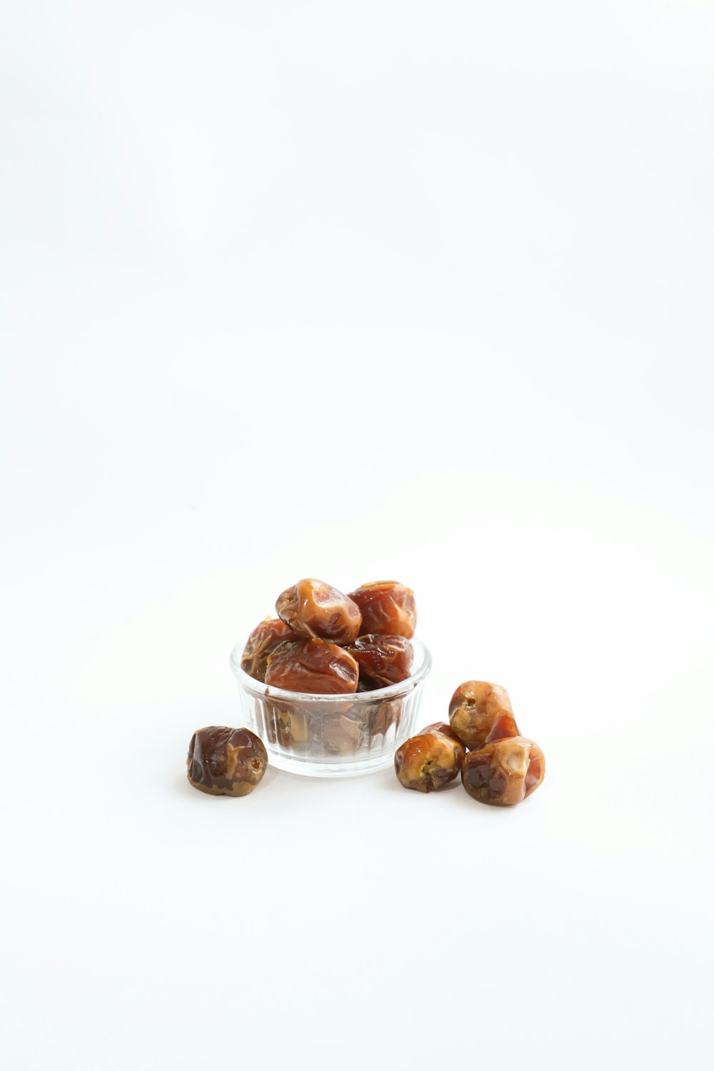 a glass bowl filled with raisins on top of a white table