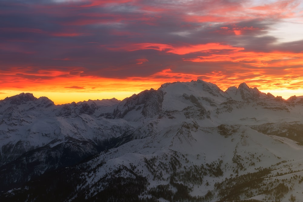 a sunset over a snow covered mountain