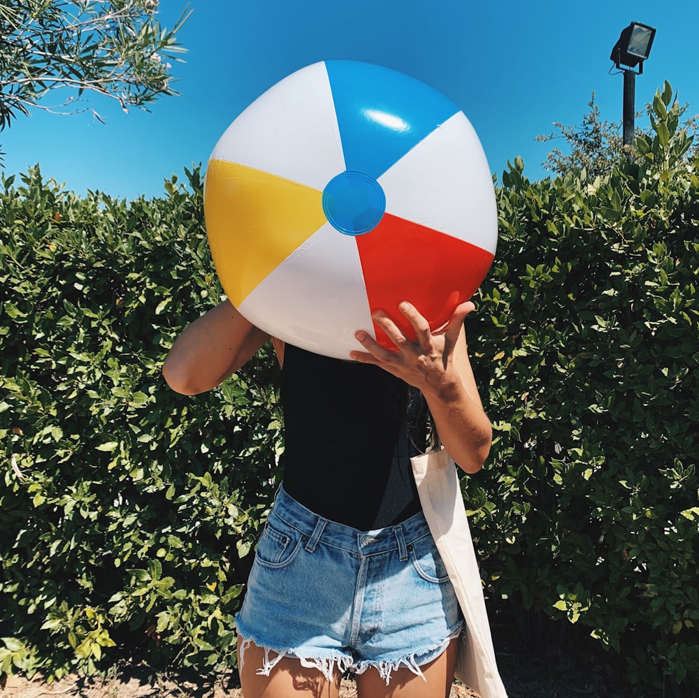 a woman holding a large beach ball in front of her face