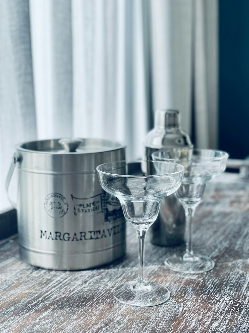 three martini glasses sitting on a table next to a can