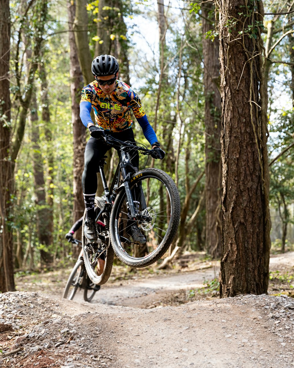 a man riding a bike through a forest