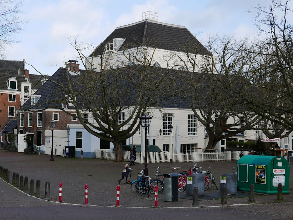 a group of people riding bikes next to a tall white building