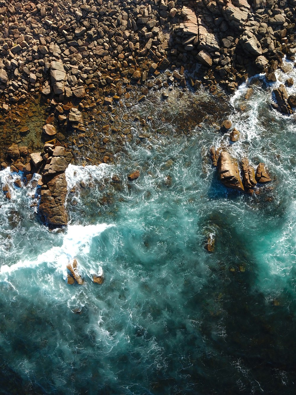 an aerial view of a body of water surrounded by rocks