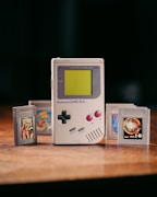 Gameboy cartridges neatly protected inside clear plastic sleeves on a wooden table.