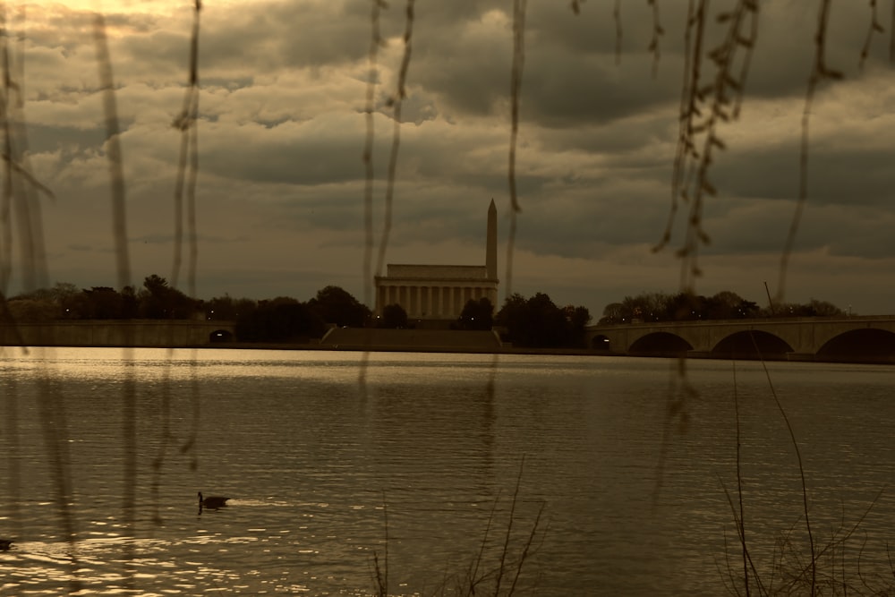 a body of water with a bridge in the background