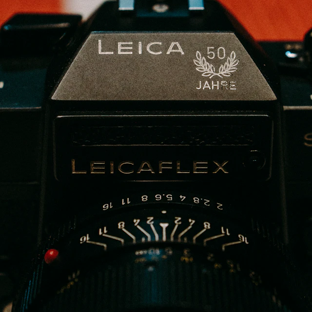 Vintage Leica camera with a green finish sitting on a tabletop