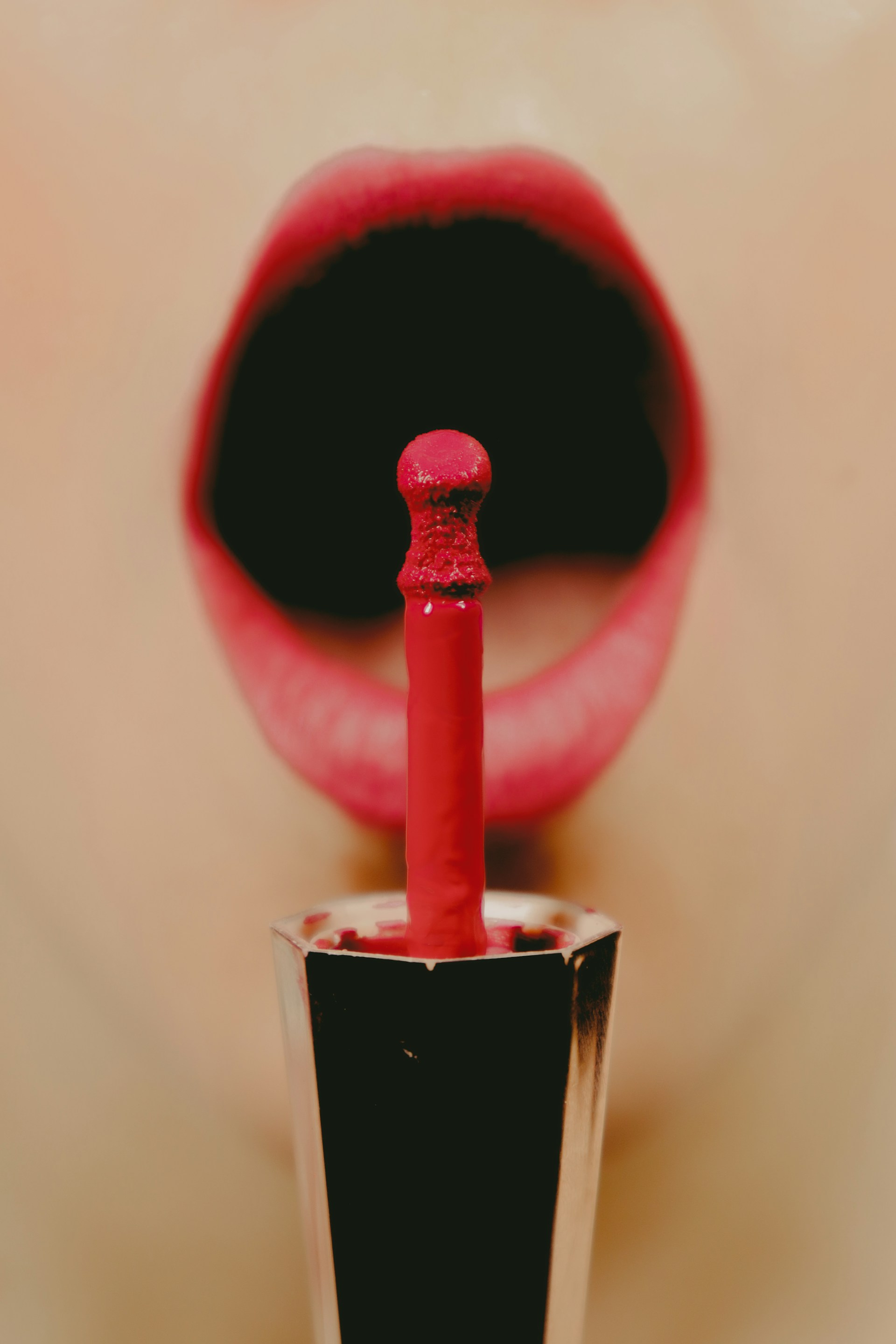 Close-up of a professional makeup artist applying lipstick to a client.