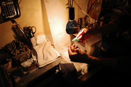 Artisan hands polishing a brass garden decor piece under warm workshop lighting.