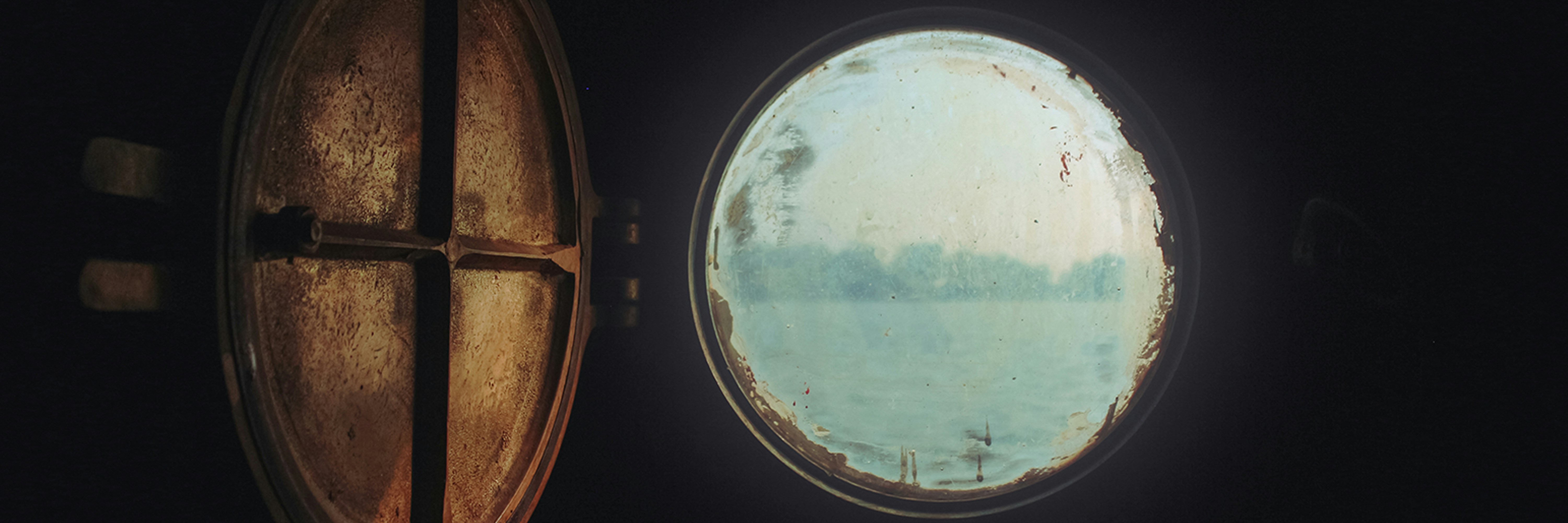 una ventana redonda con vistas a un cuerpo de agua