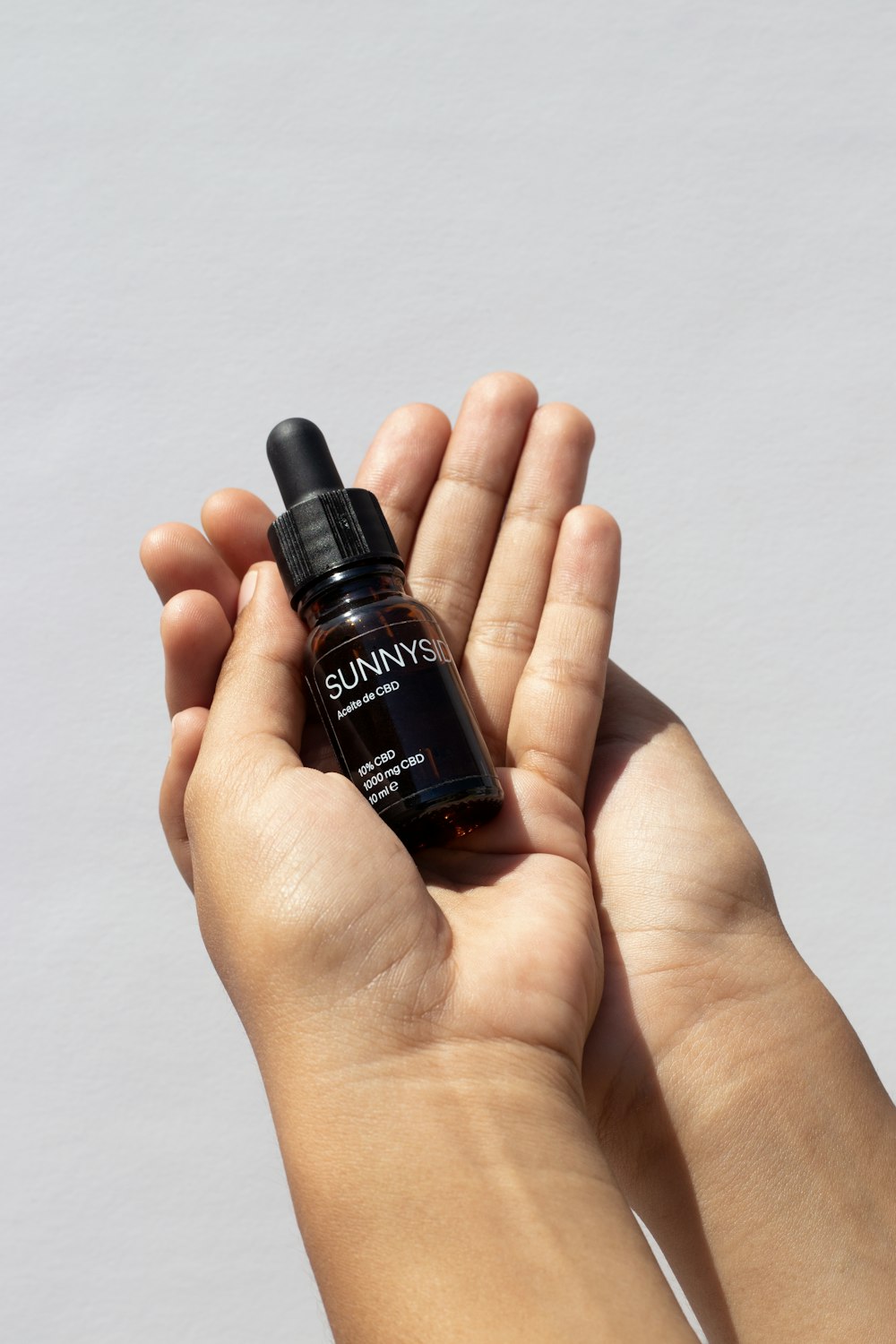 a person holding a small bottle of essential oil