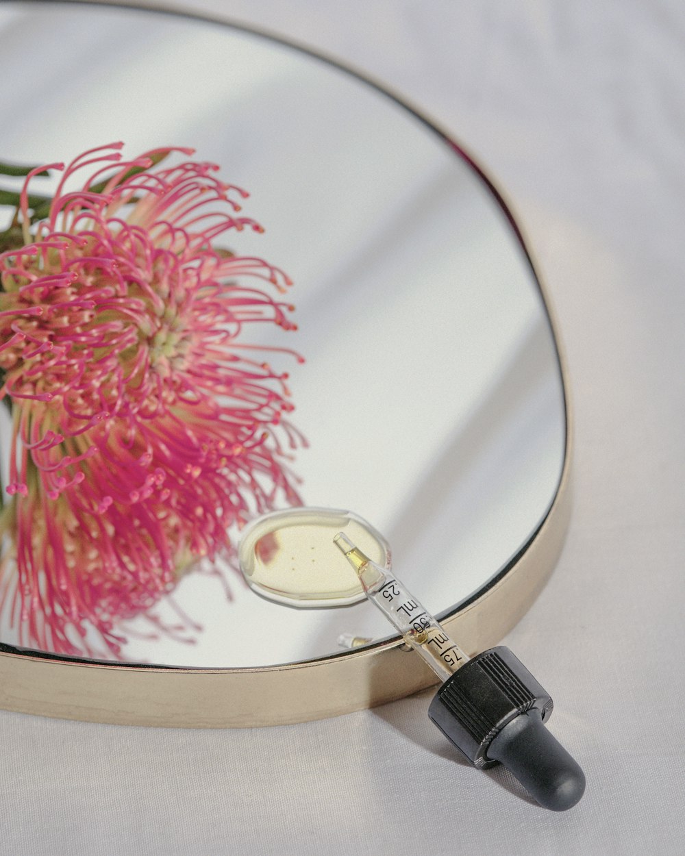 a mirror with a pink flower on it