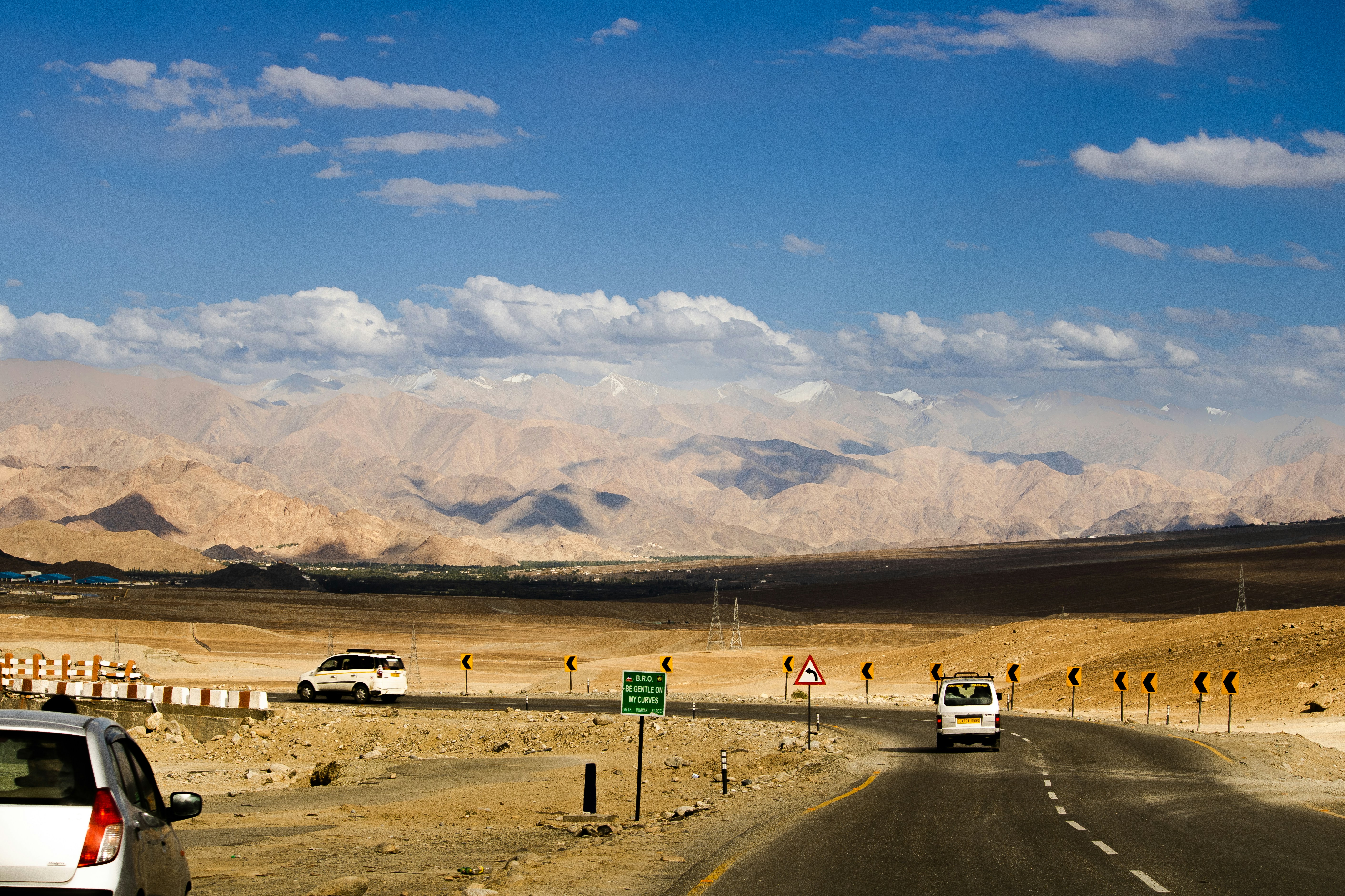 a desert road with mountains in the background