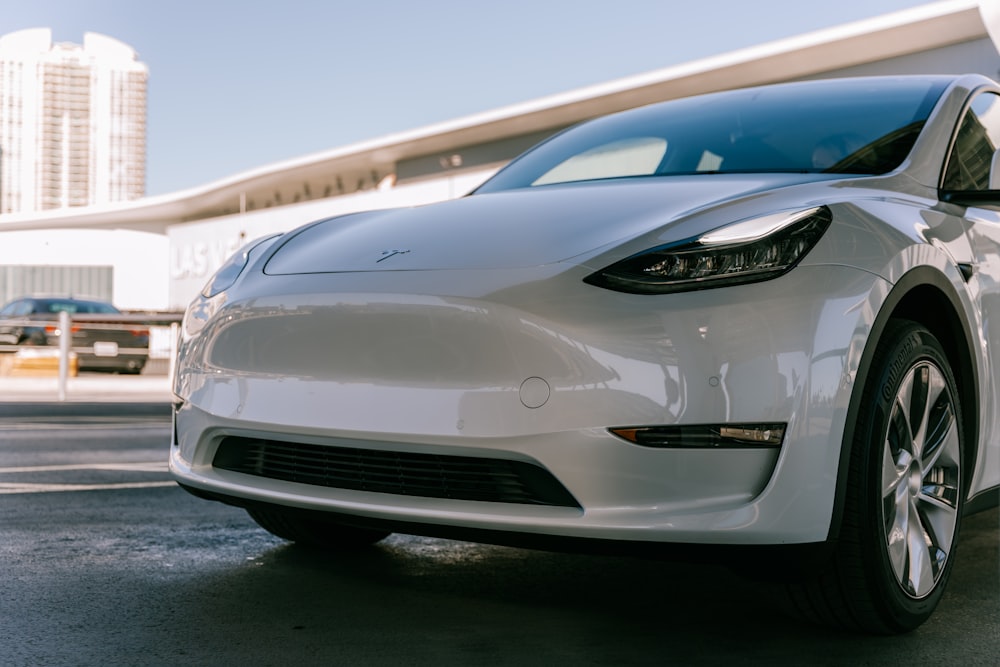 a white electric car parked in front of a building