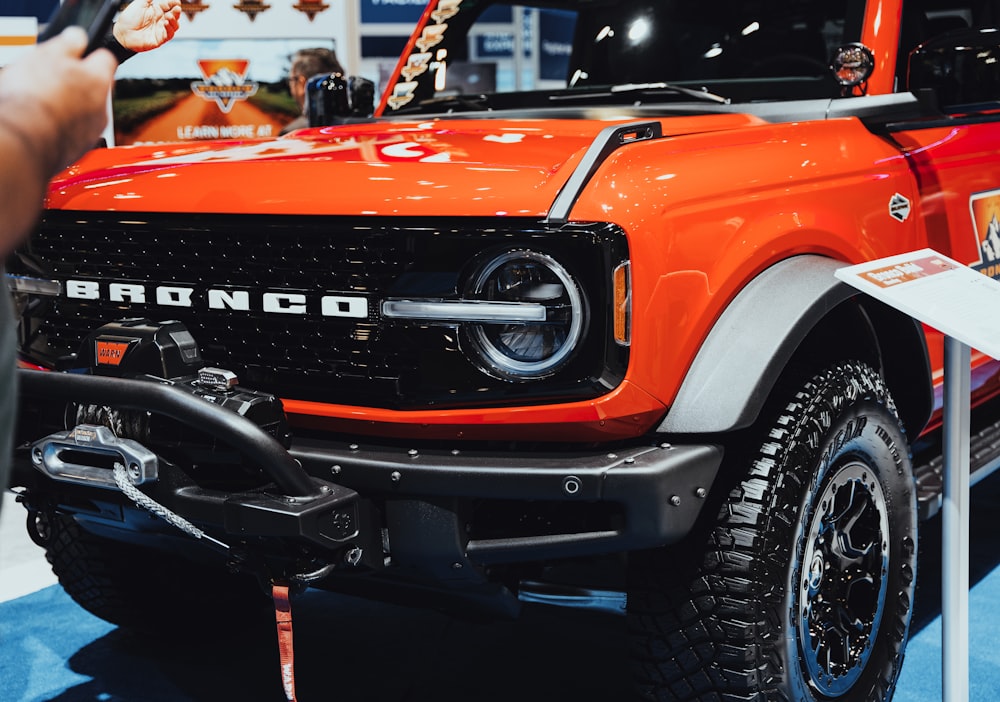 an orange truck is on display at a car show