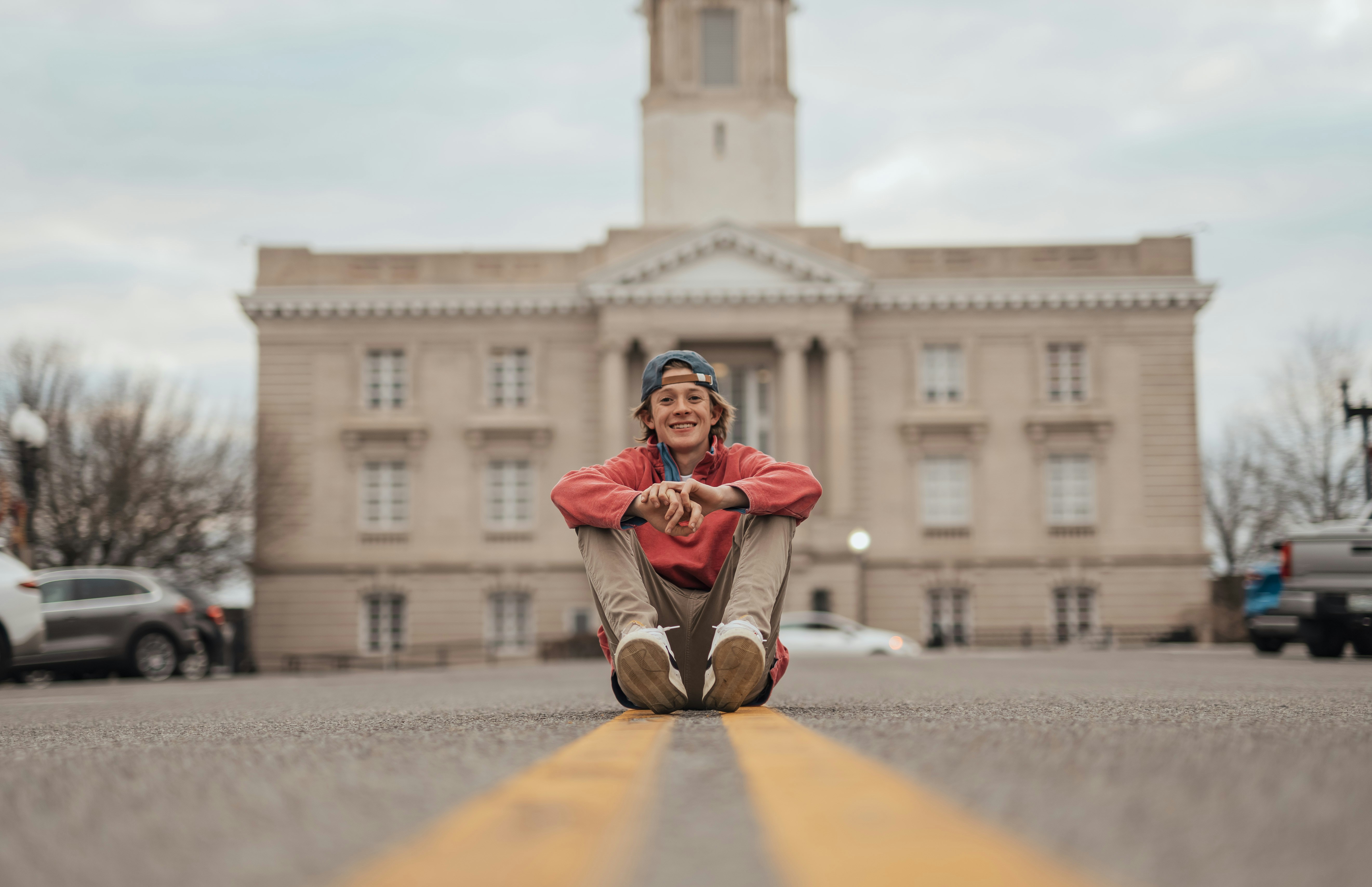Eine Person, die vor einem Gebäude auf dem Boden sitzt